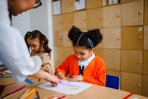 Free Woman Helping Student in Coloring Stock Photo
